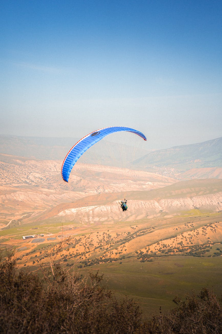 paraglider flying over hills